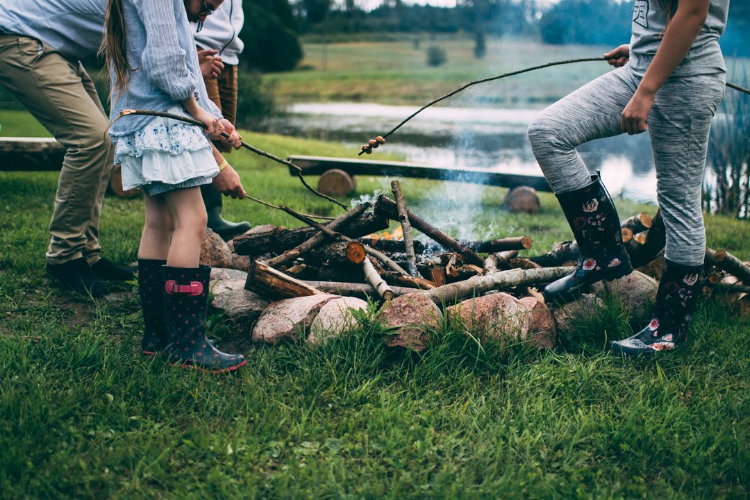 people roasting marshmallows around a campfire